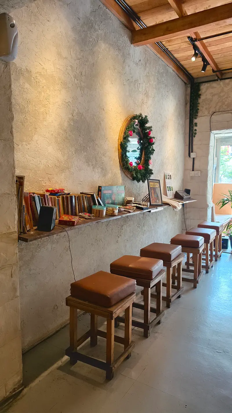 A row of leather stools along the window bar under a timber-beamed ceiling